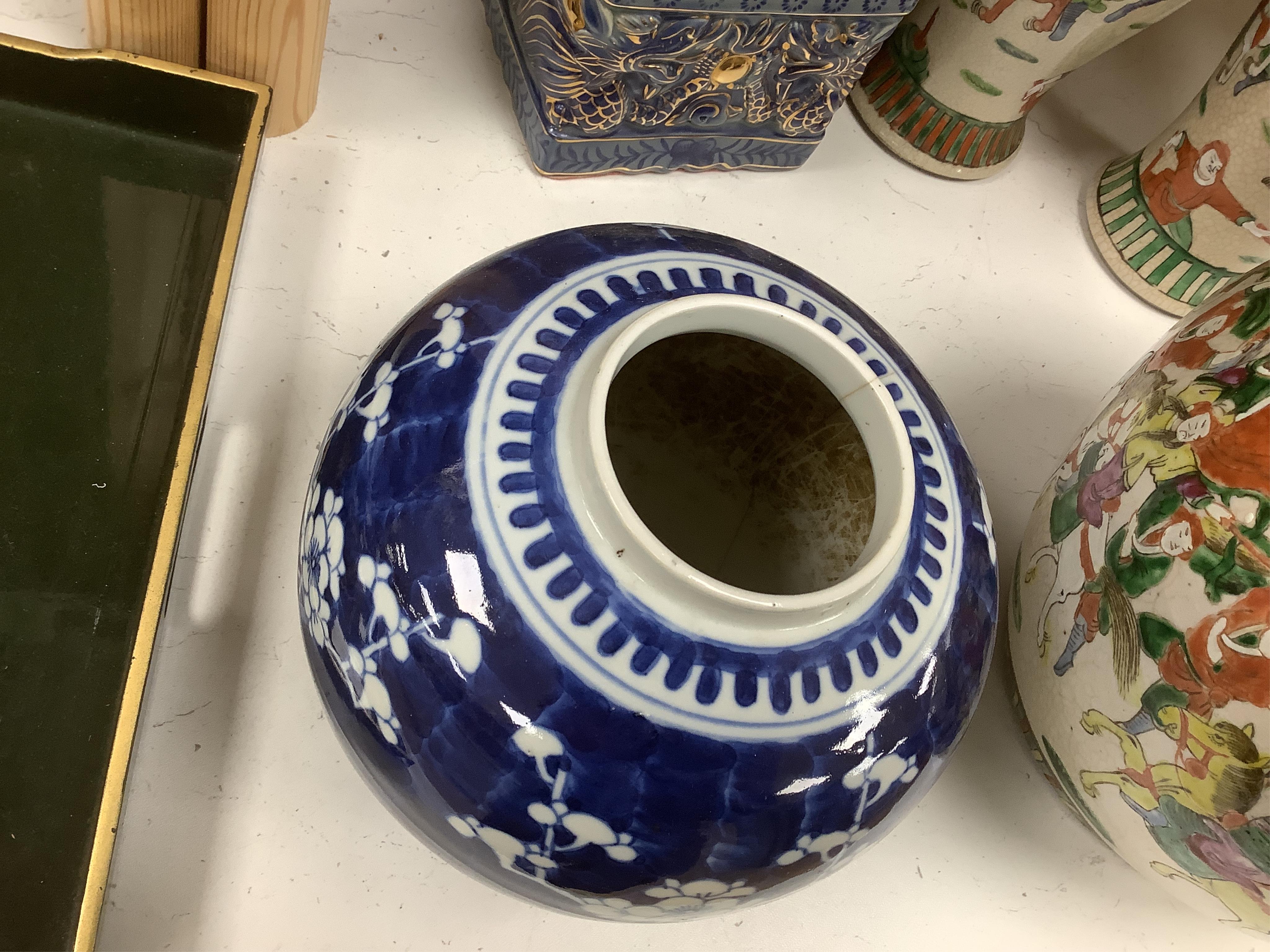 A group of Chinese ceramics including a large blue and white sleeve vase, circa 1900, two crackle glazed vases and covers, similar jar, a prunus jar and a pair of lion dogs, largest 36cm (7). Condition - poor to fair